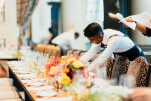 a waiter setting a table before an event