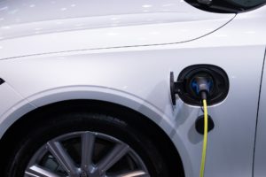 White electric car plugged in being recharged